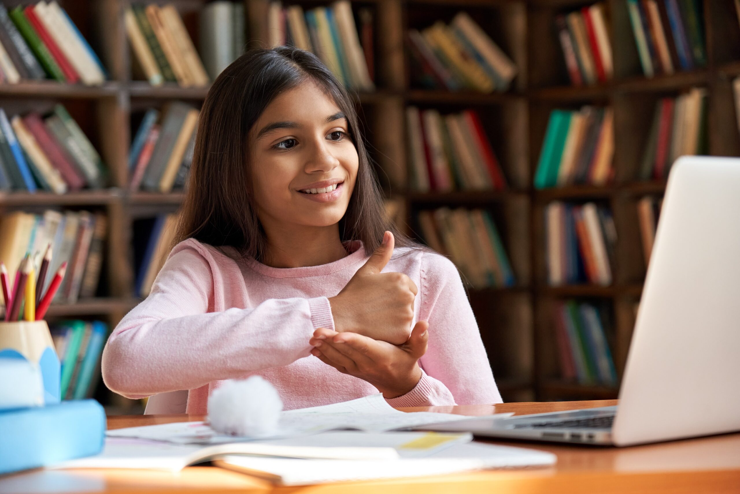 Girl in school making ASL sign for help