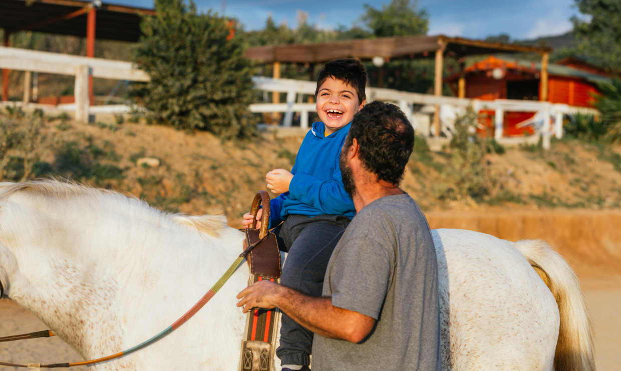 Child with disabilities on a horse for horse therapy