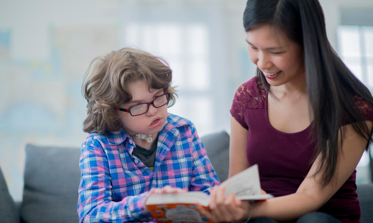 Adult helping a child with disabilities to read